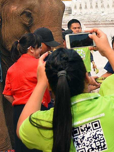 Femme prenant une photo avec son smartphone au Laos.